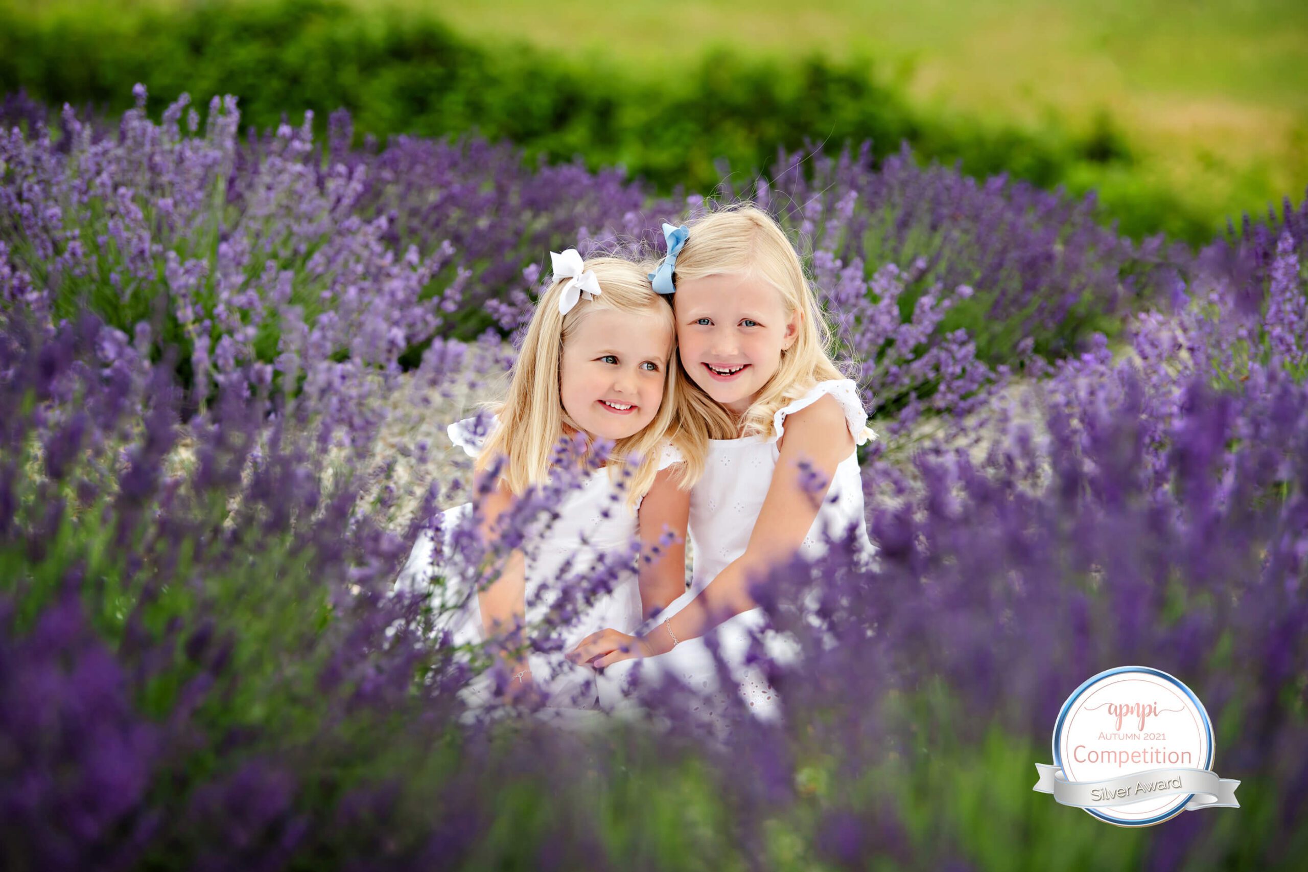 award-winning lavender field photo of two sisters sitting amongst the flowers