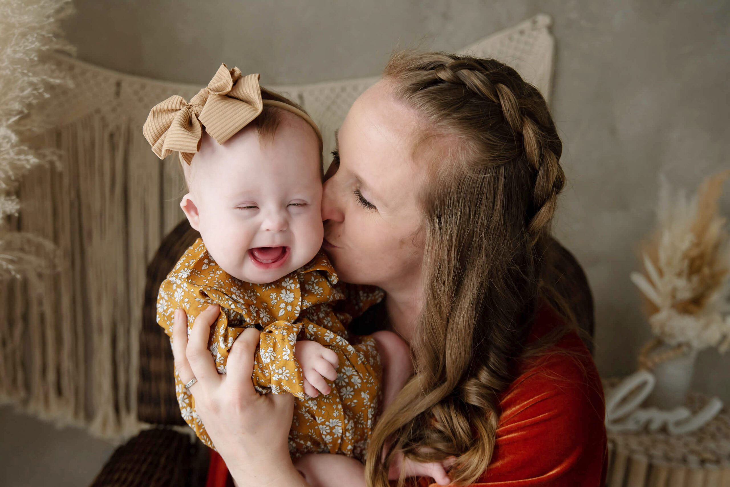 Mom kissing down syndrome baby laughing Burlington Newborn Photographer