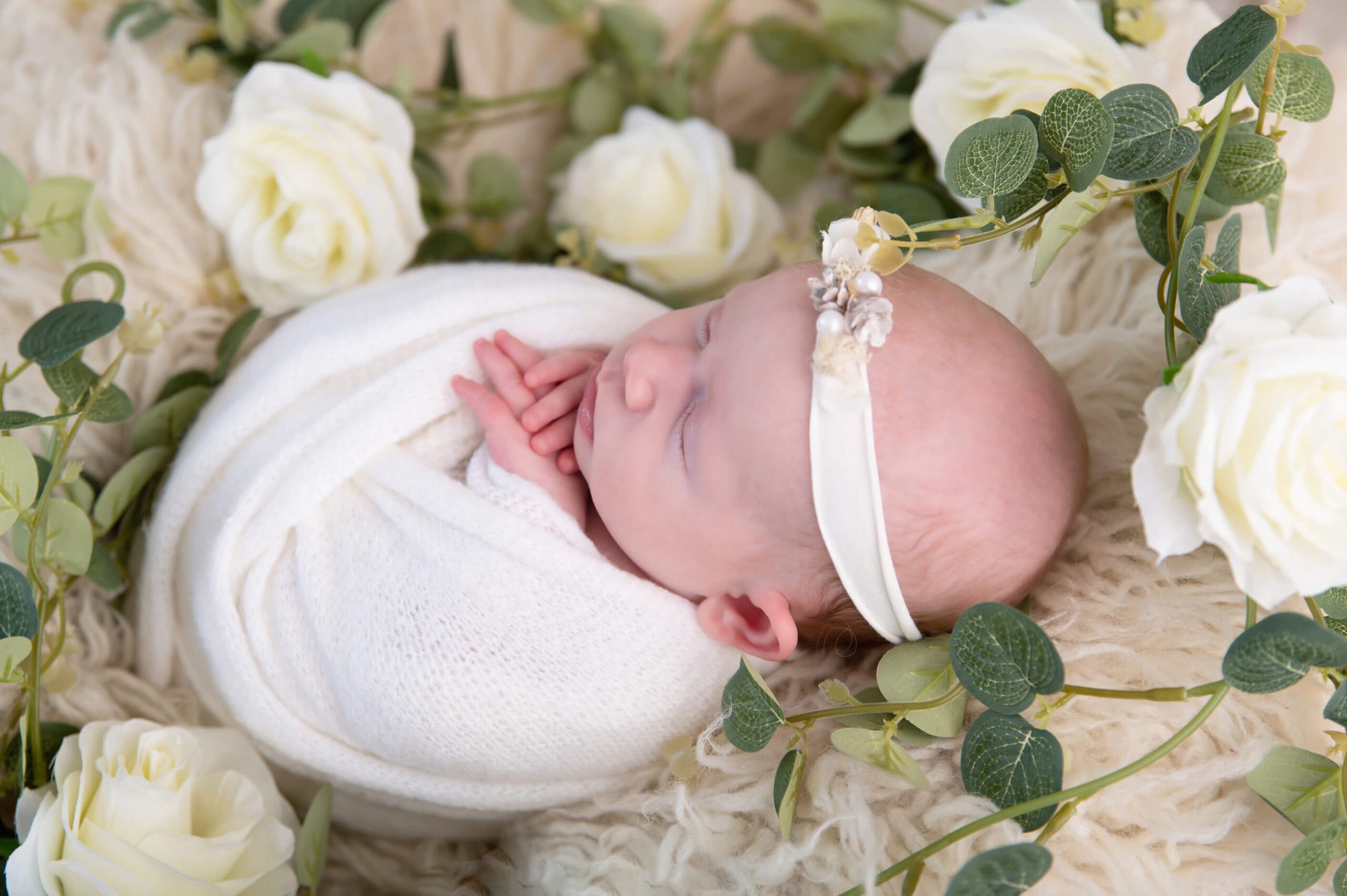 side view of newborn girl in white floral set