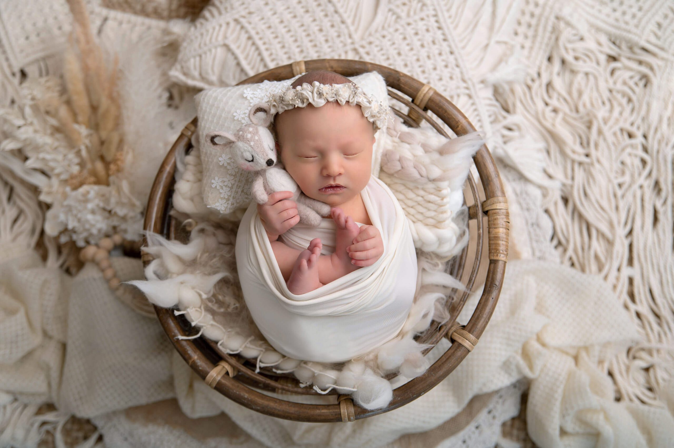 boho style Burlington newborn photographer holding a fawn baby prop