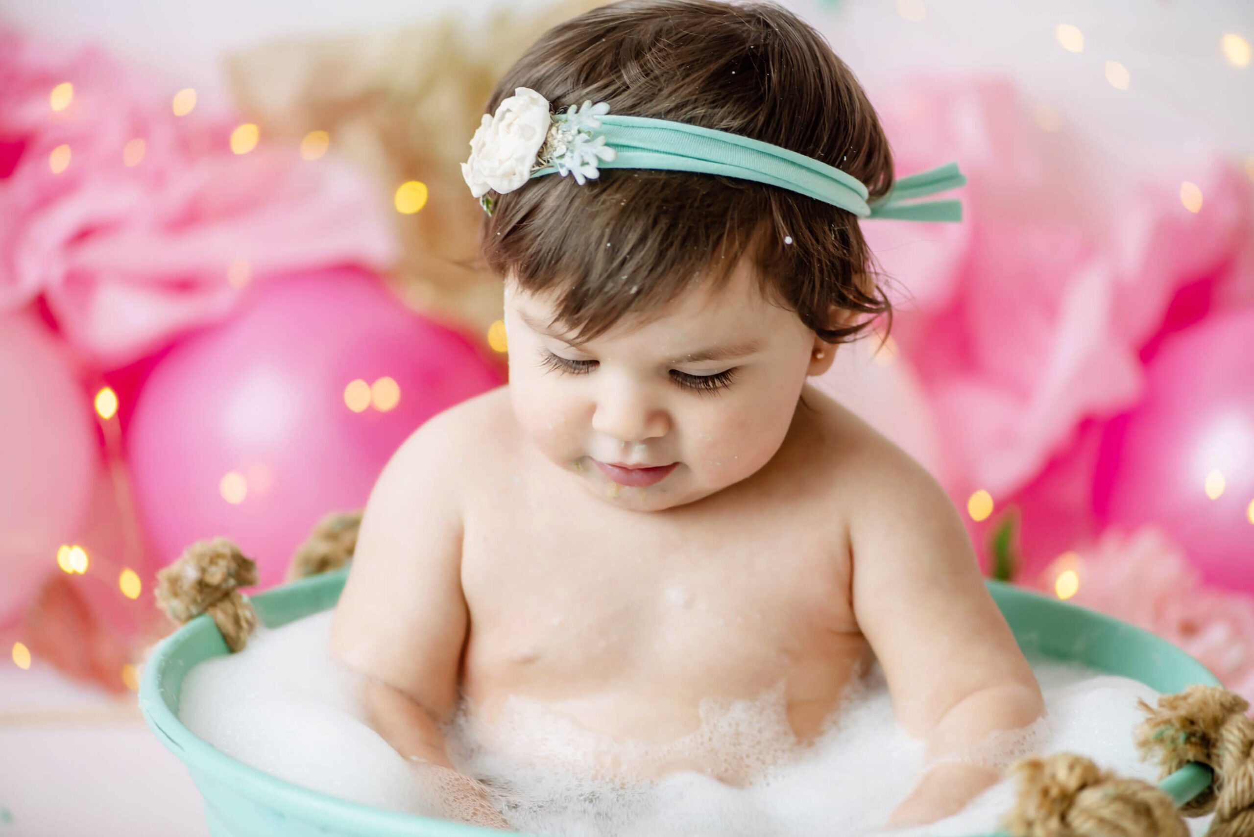 up close in bath tub photo of baby at her cake smash session in studio Burlington Ontario