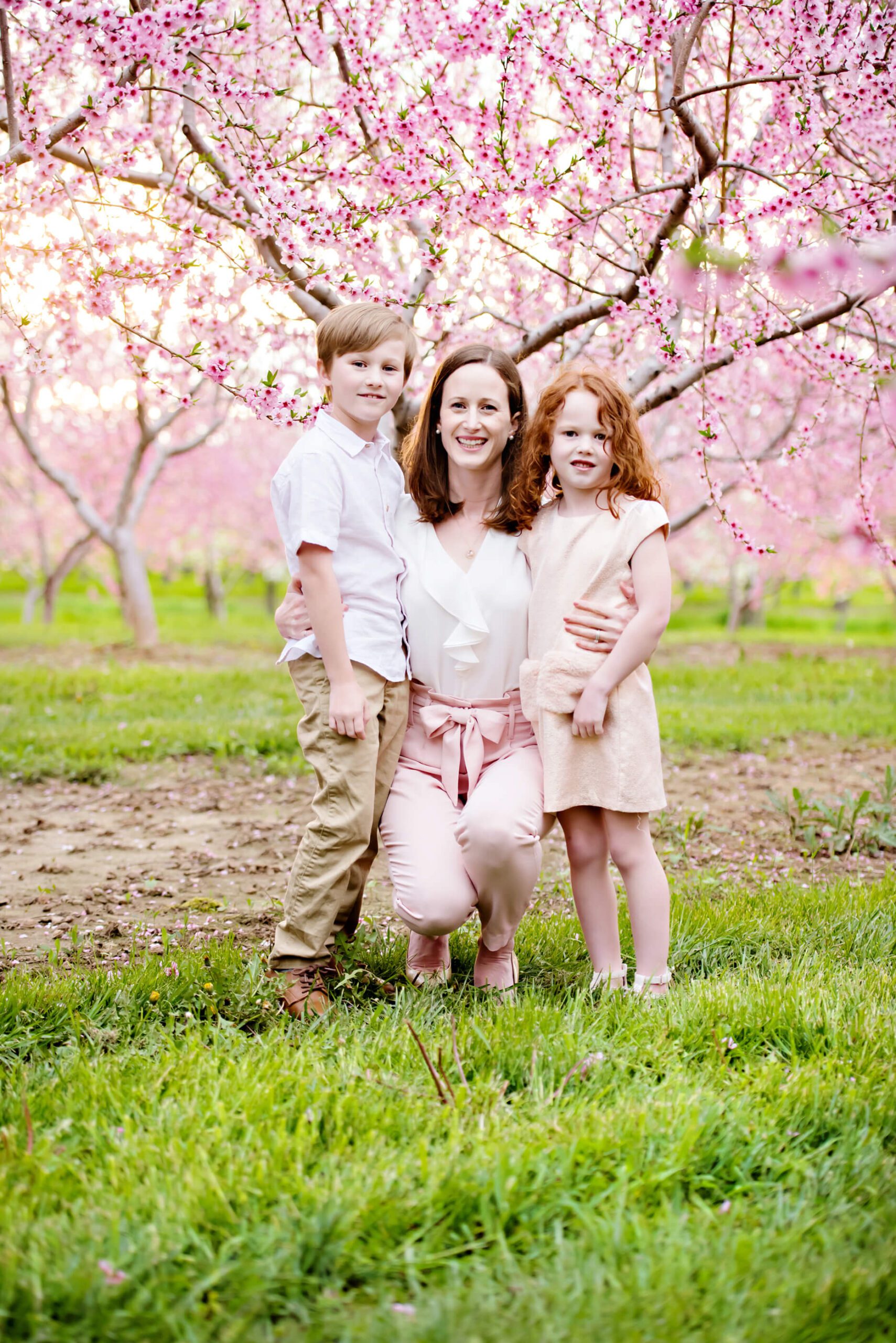 mom with son and daughter at their cherry blossom mini session