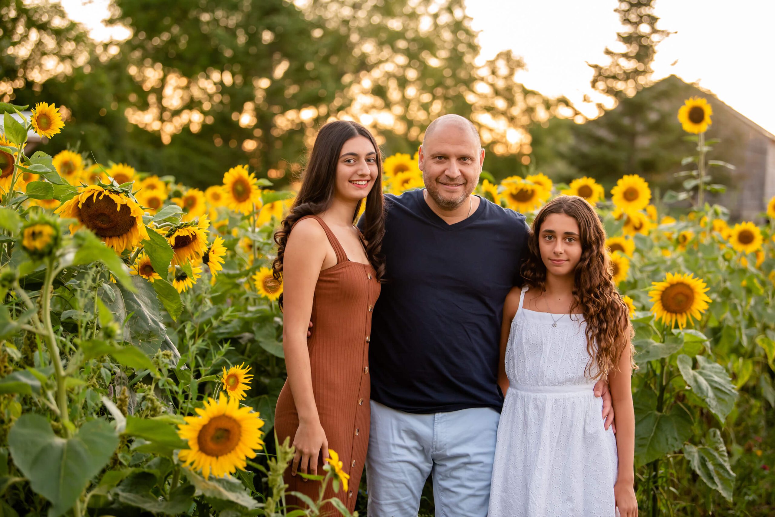 dad with daughters at the sunflower farm
