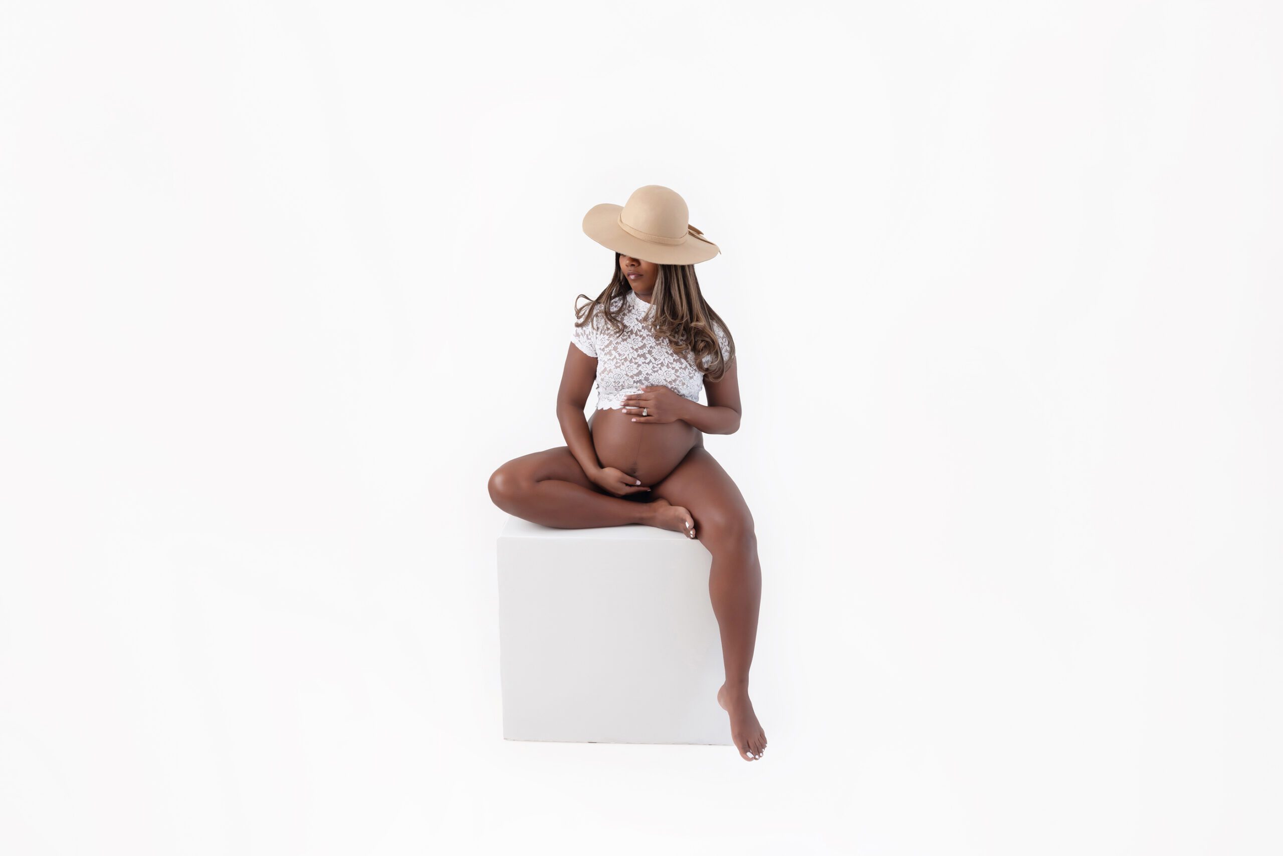 all white mom to be sitting on a posing box for her Toronto maternity photography session