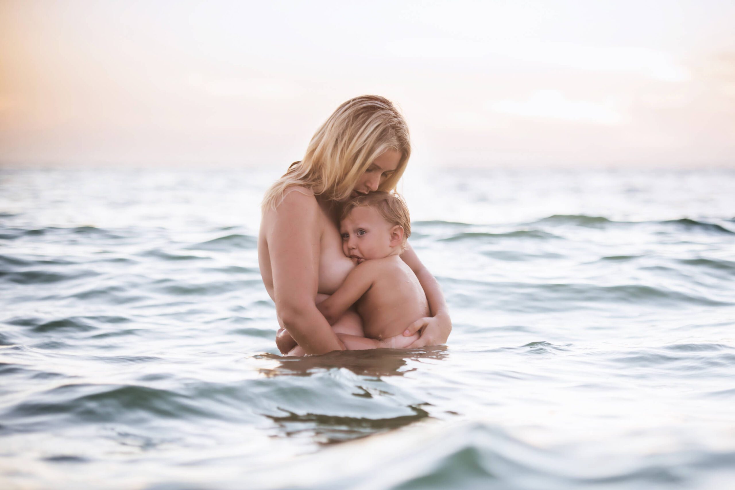 Mom breastfeeding baby in the ocean Toronto Lactation Consultant