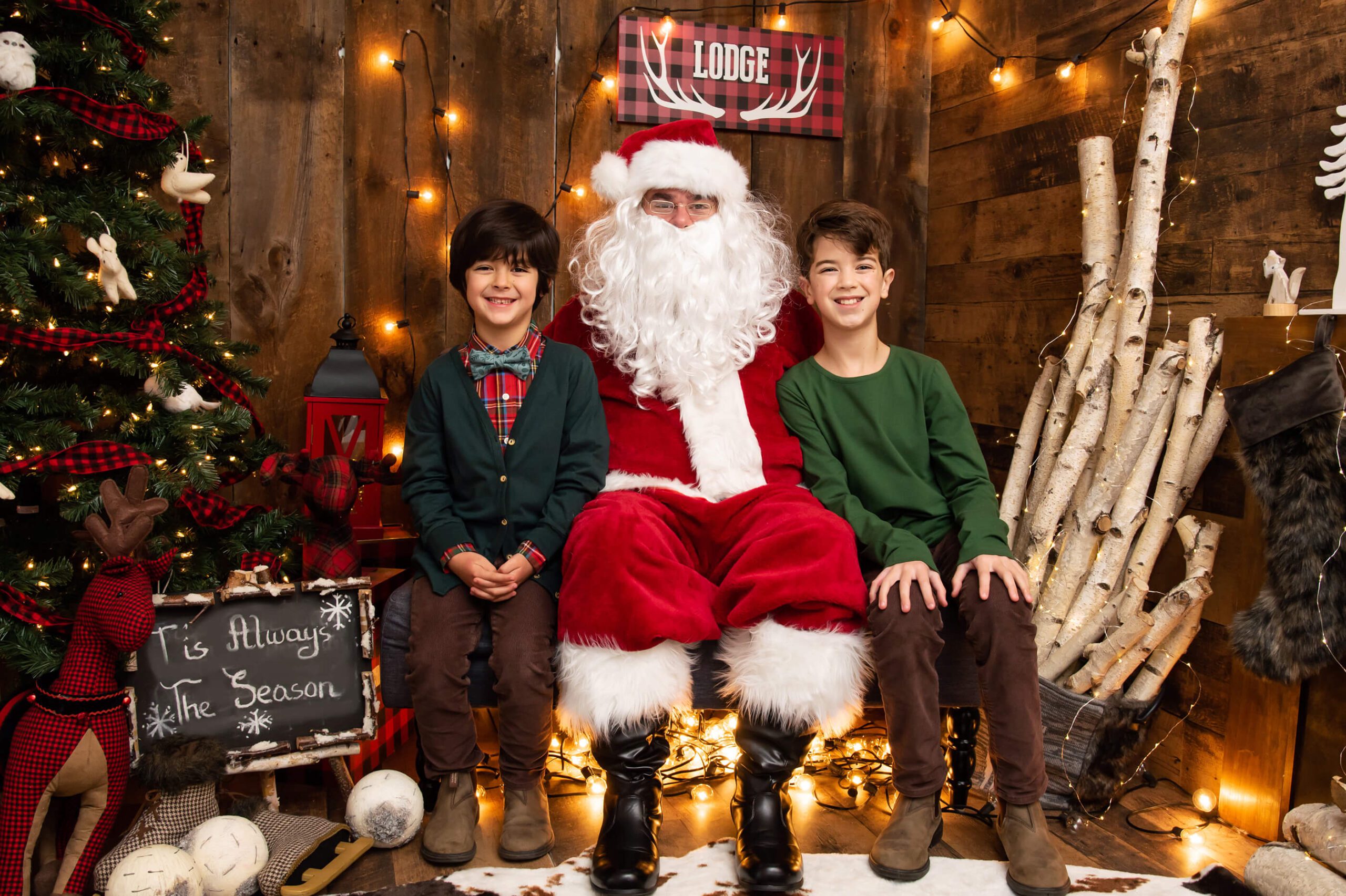 Santa sitting in a Lodge cabin set with two boys WinterFest Canada's Wonderland