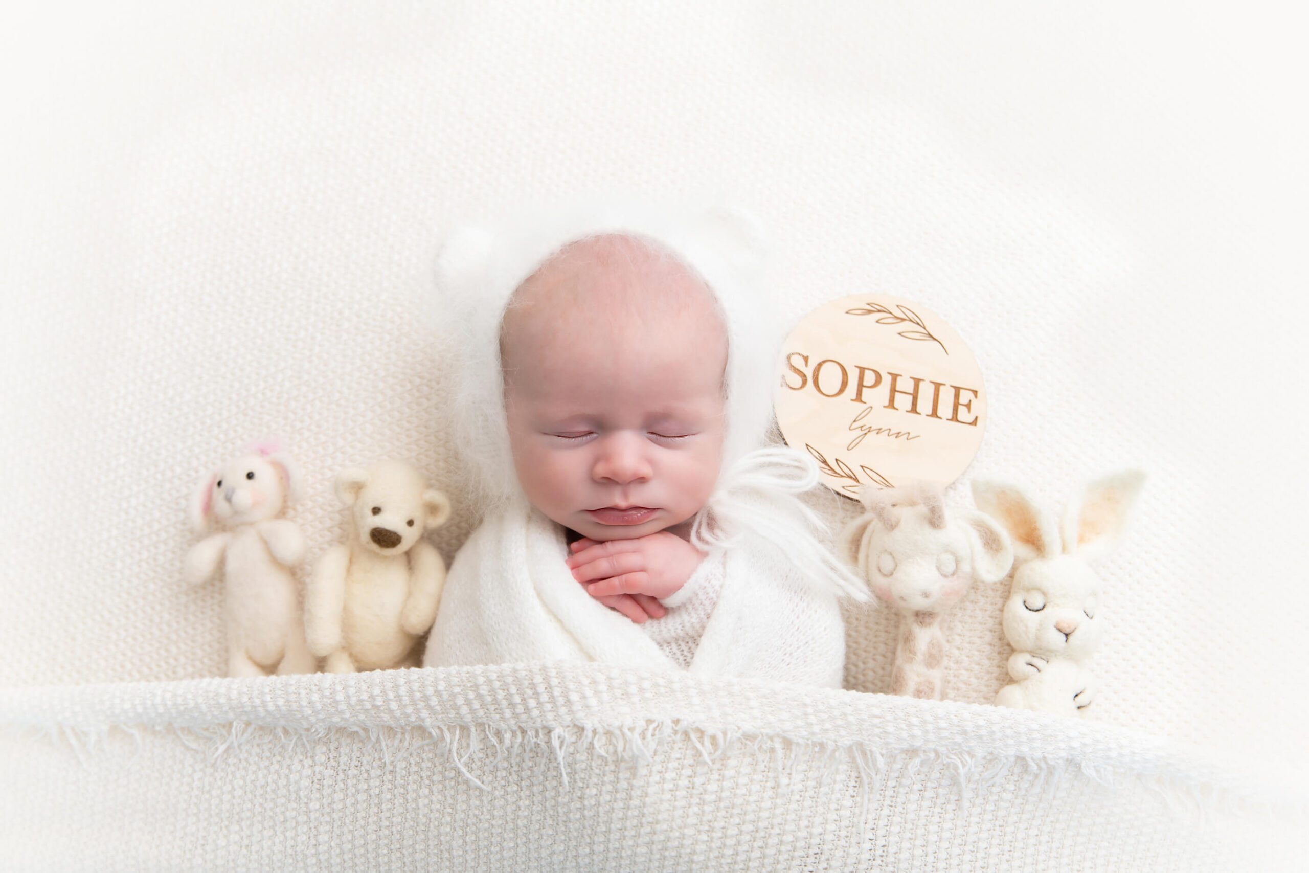 newborn girl in all white laying down with angora bear hat and lovies Cambridge newborn photography