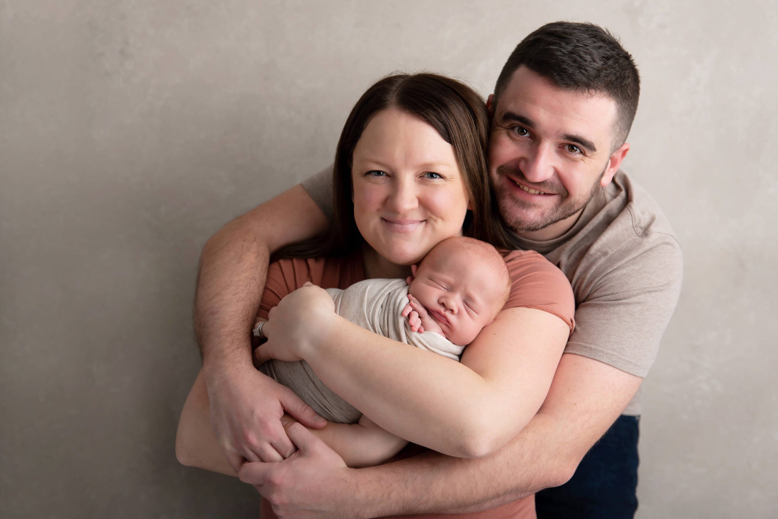 mom and dad with newborn baby boy cuddling Burlington photographer