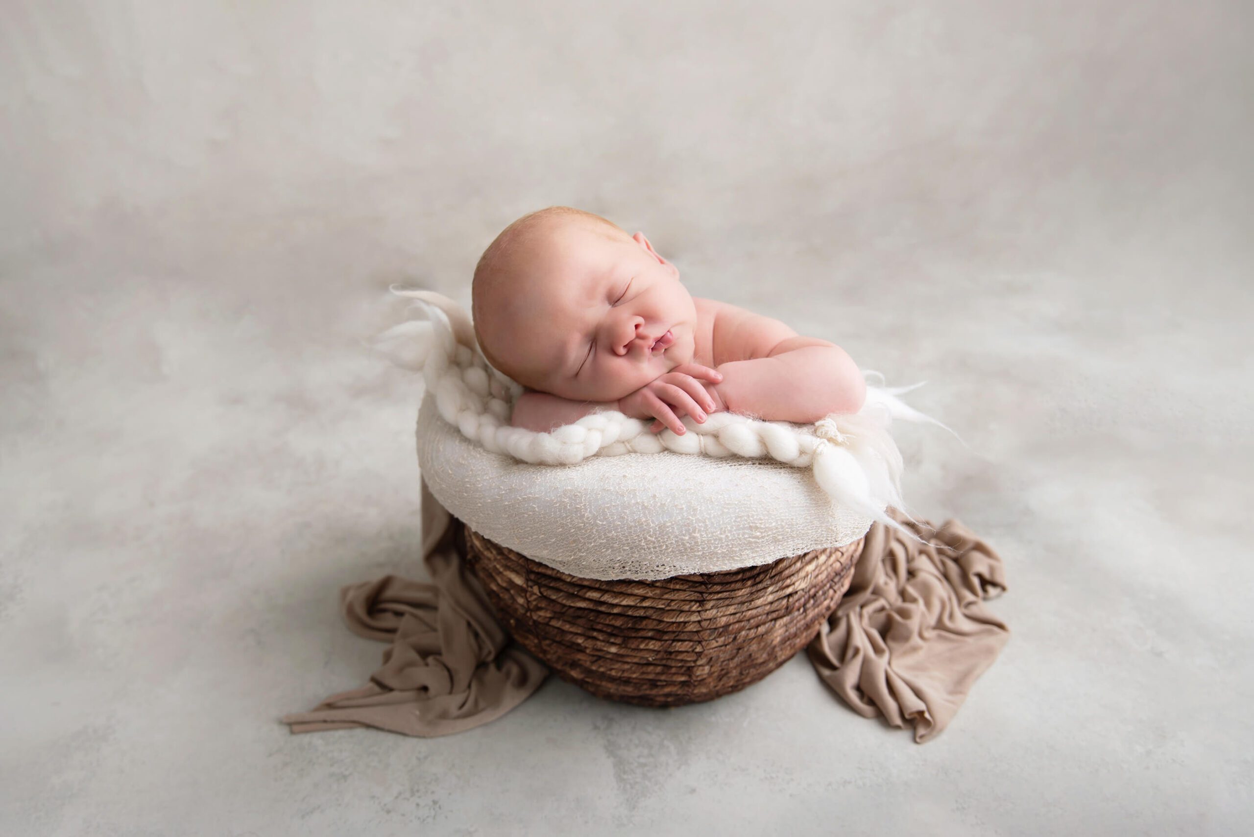 beige setup with newborn boy in a bowl Burlington newborn photos