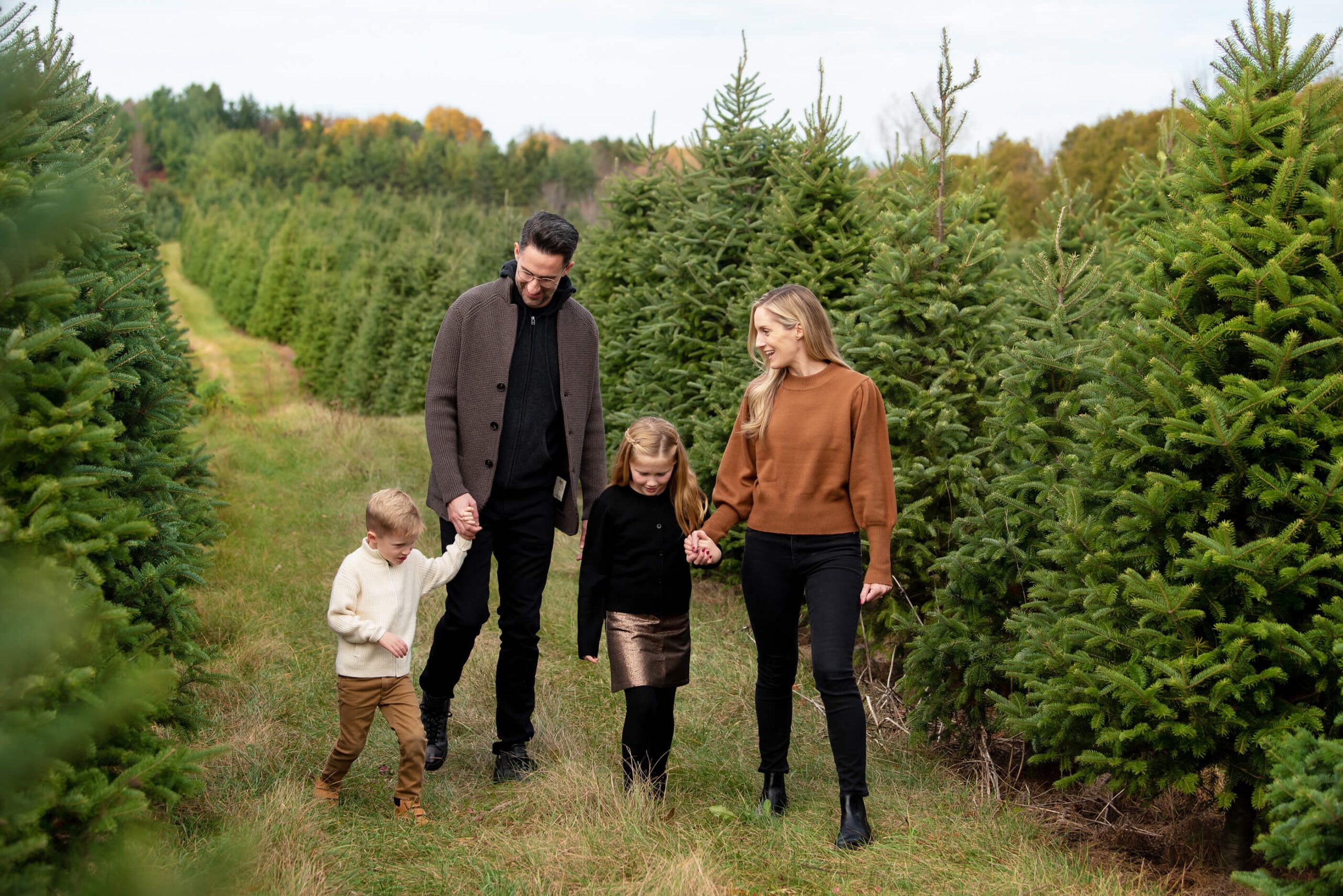 A family walking through the trees at Merry Farms Tree Farm