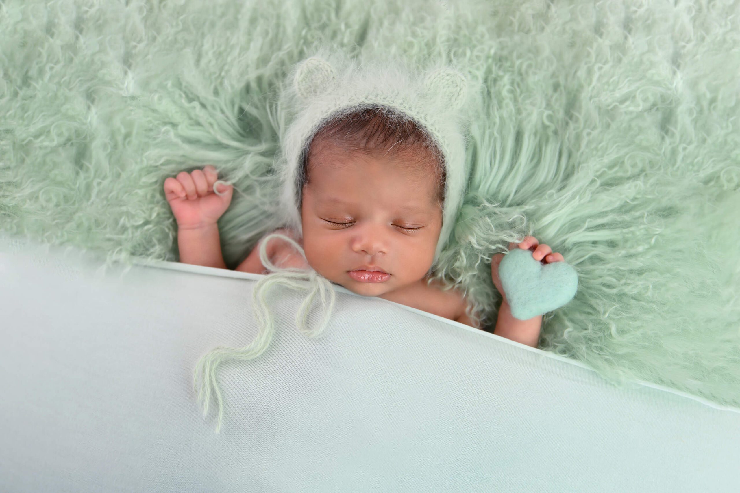 newborn baby boy monochrome in mint green holding a tiny heart Toronto Newborn Photographer