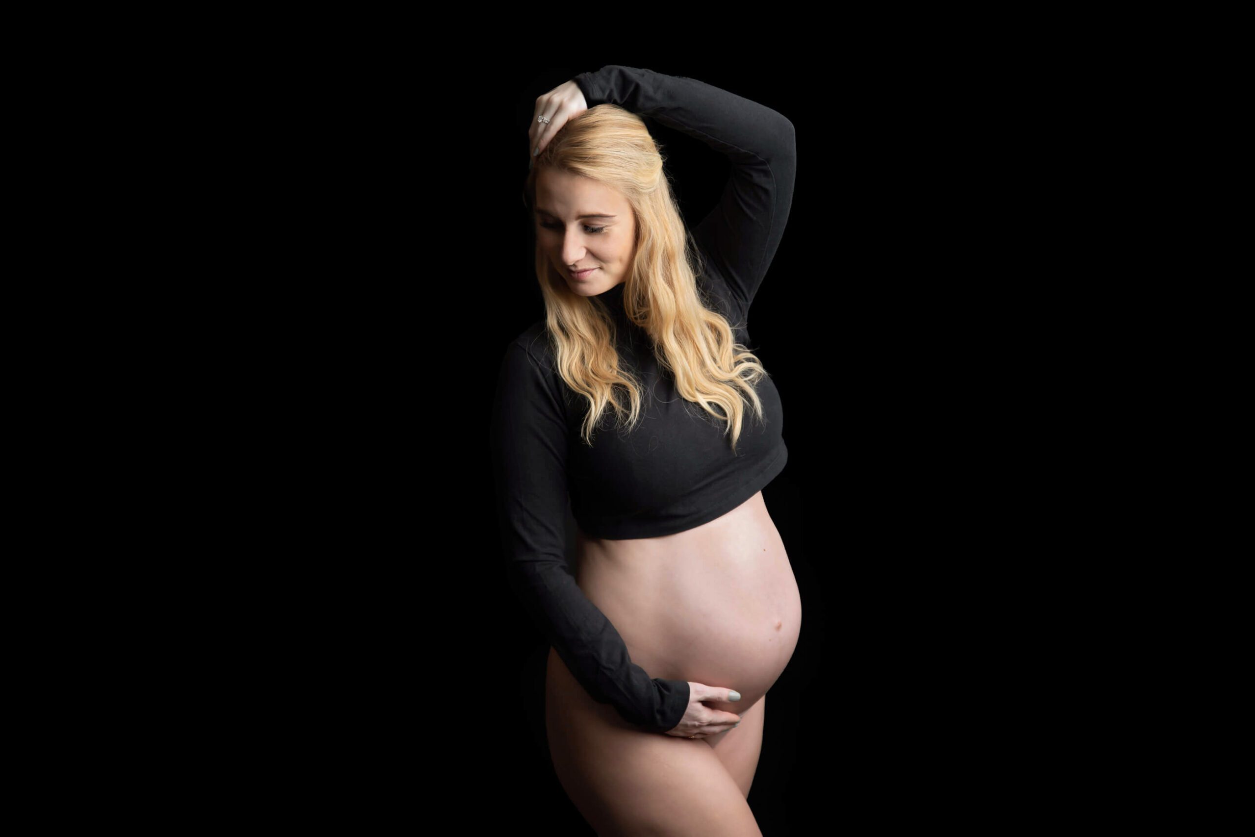 All black Burlington Ontario maternity photography mom holding her arm above her head smiling