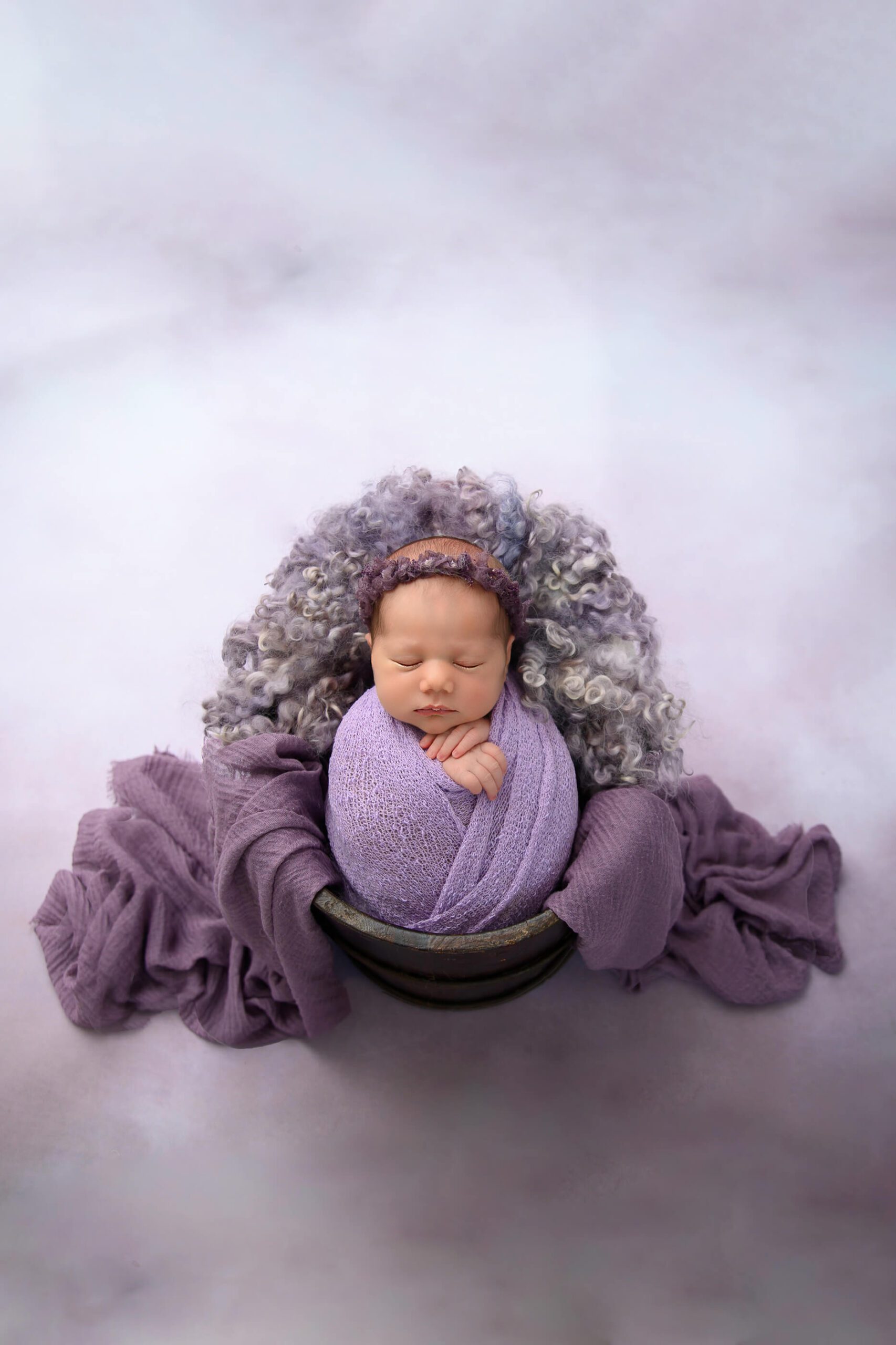 Toronto newborn photographer girl wrapped in purple in a bucket