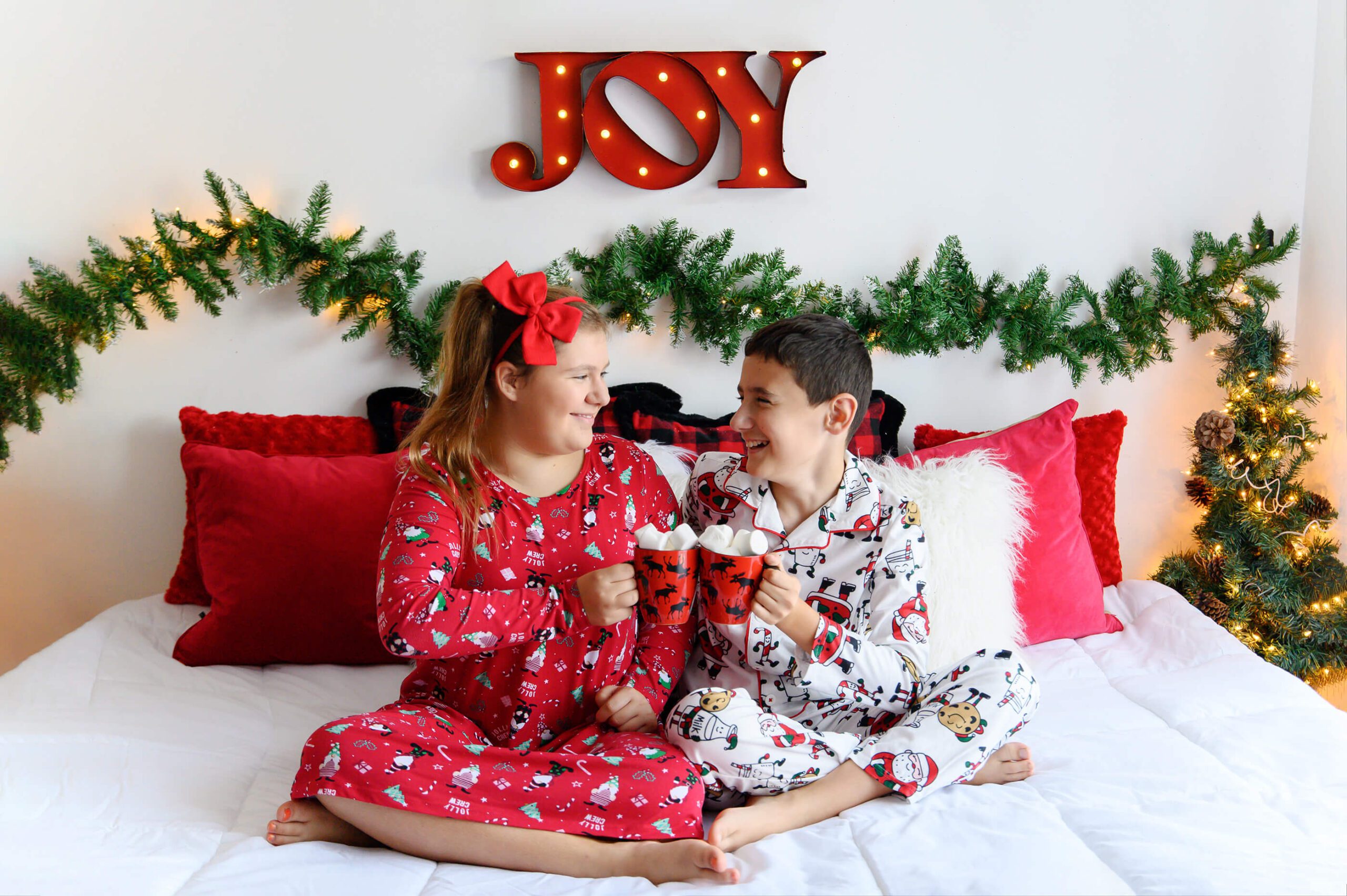 Boy and Girl sitting on a bed cheering Marshmallows Burlington, Ontario studio Christmas Mini Session