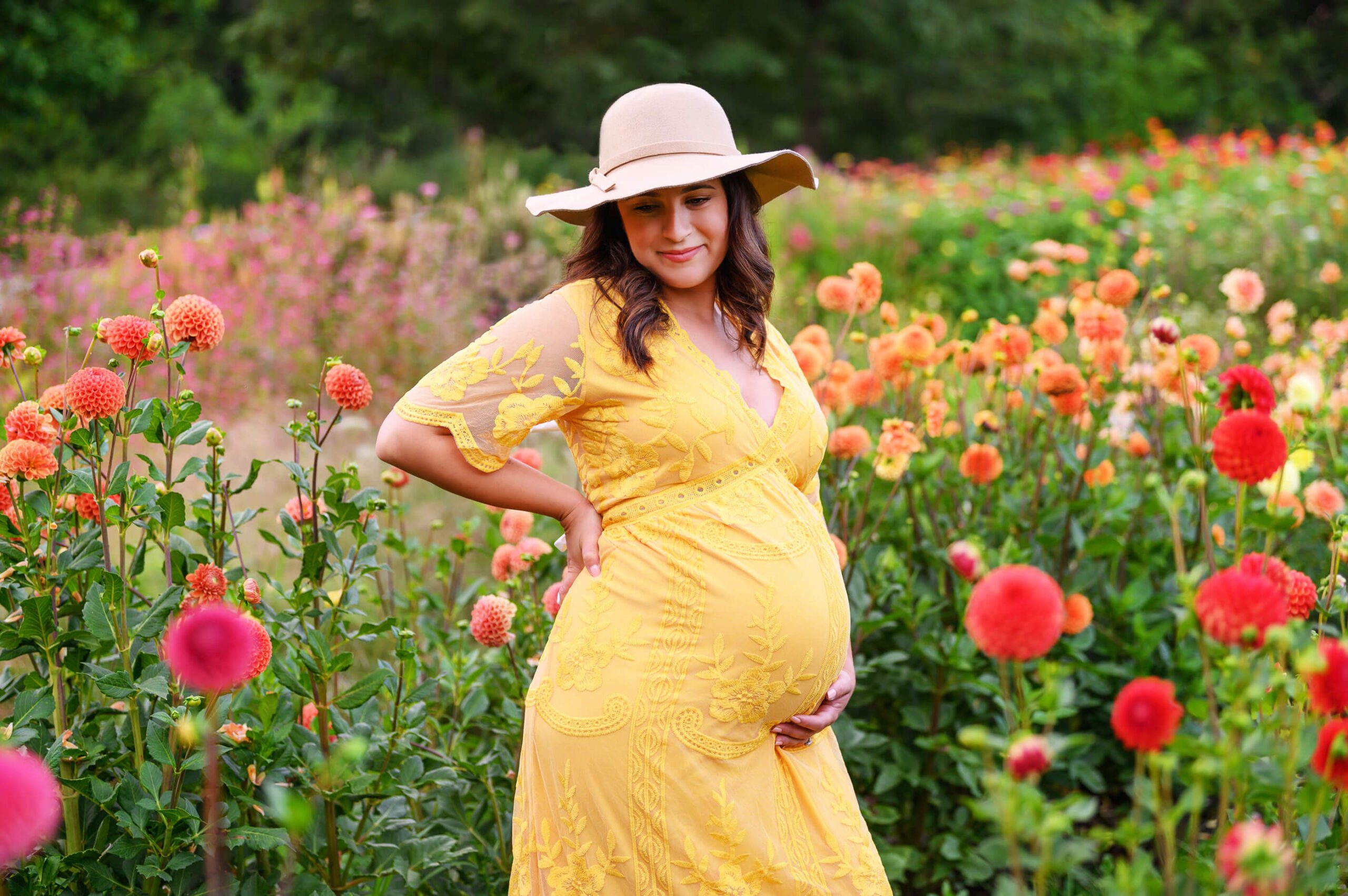 mom wearing a had and a yellow dress smiling Toronto Maternity Photographer