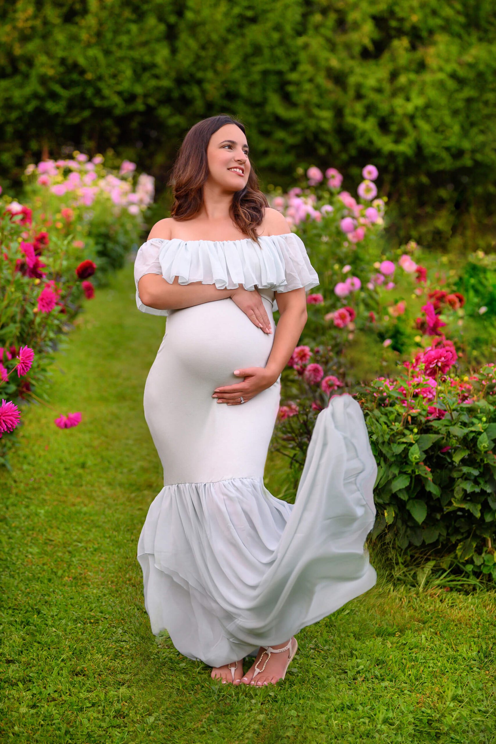mom in mint green maternity dress smiling, dress flying up