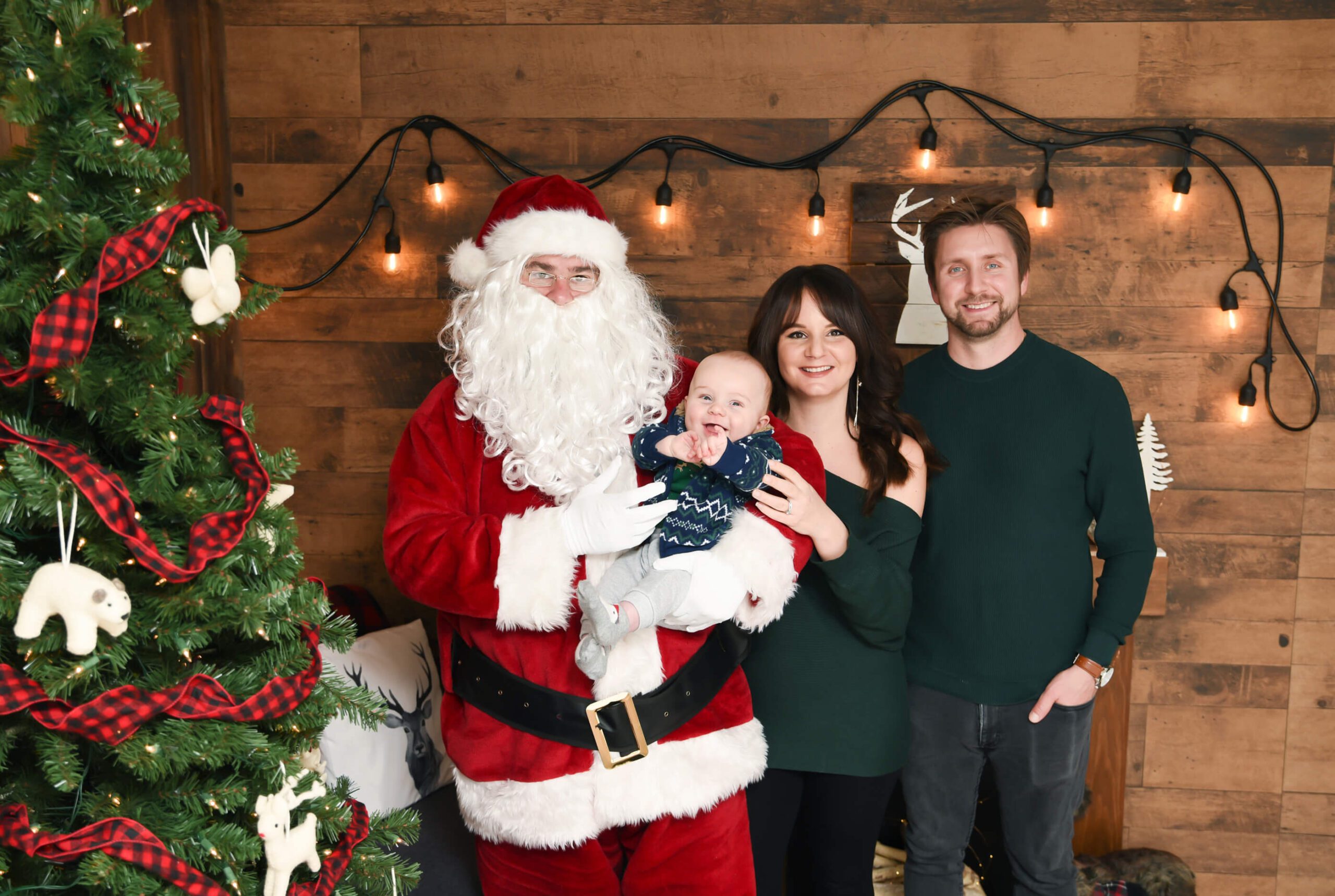 Family Santa Photos Toronto. Santa holding baby smiling with mom and dad.