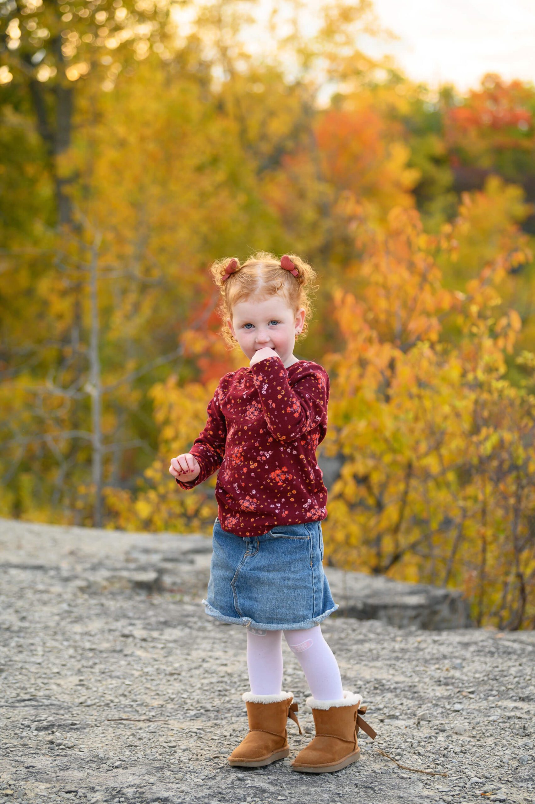 little girl with red hair wearing a red shirt and gean skirt. Toronto Family Photography.
