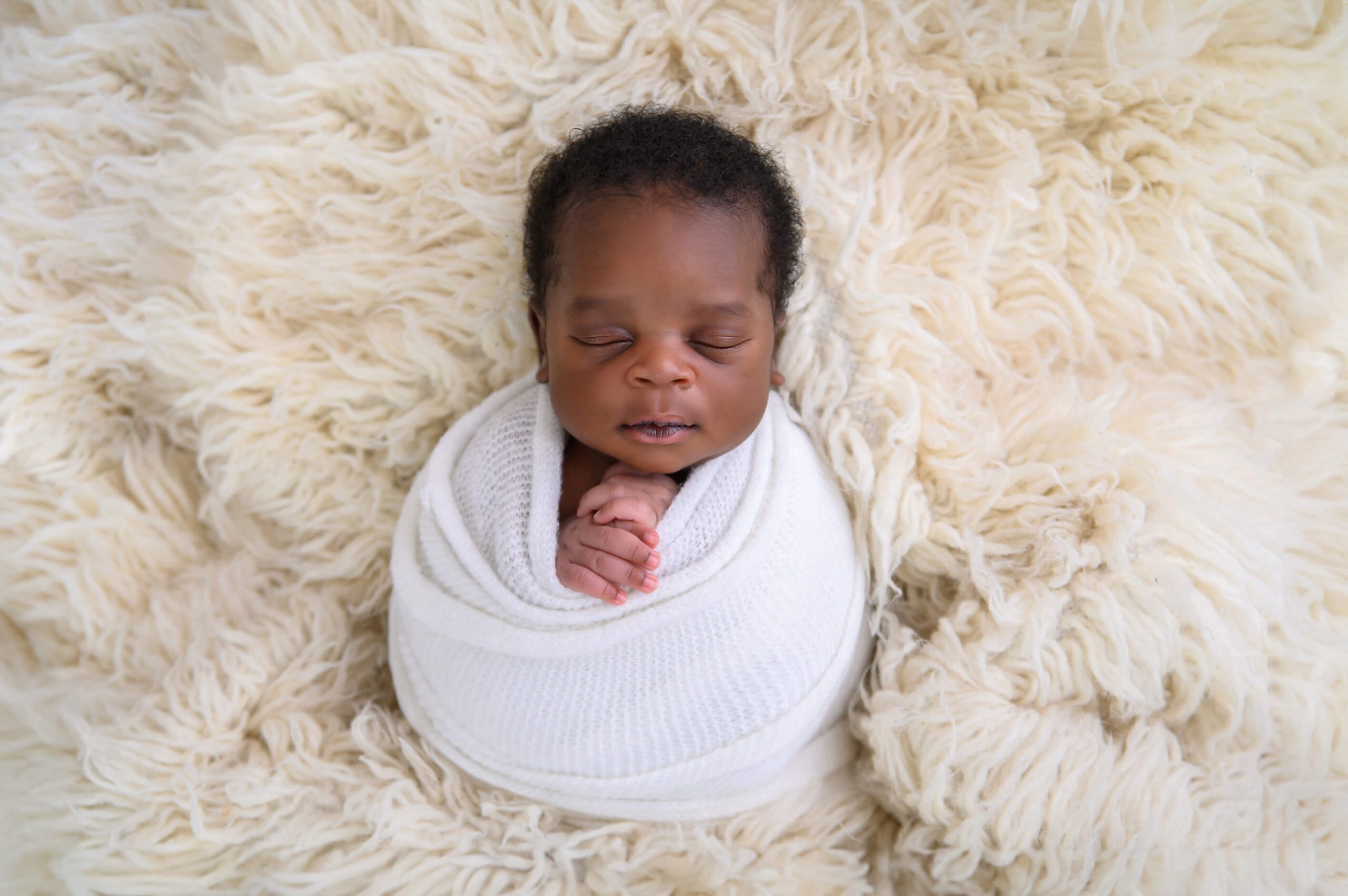 Boho newborn photography session baby boy wrapped in a white wrap. Toronto Newborn Photographer