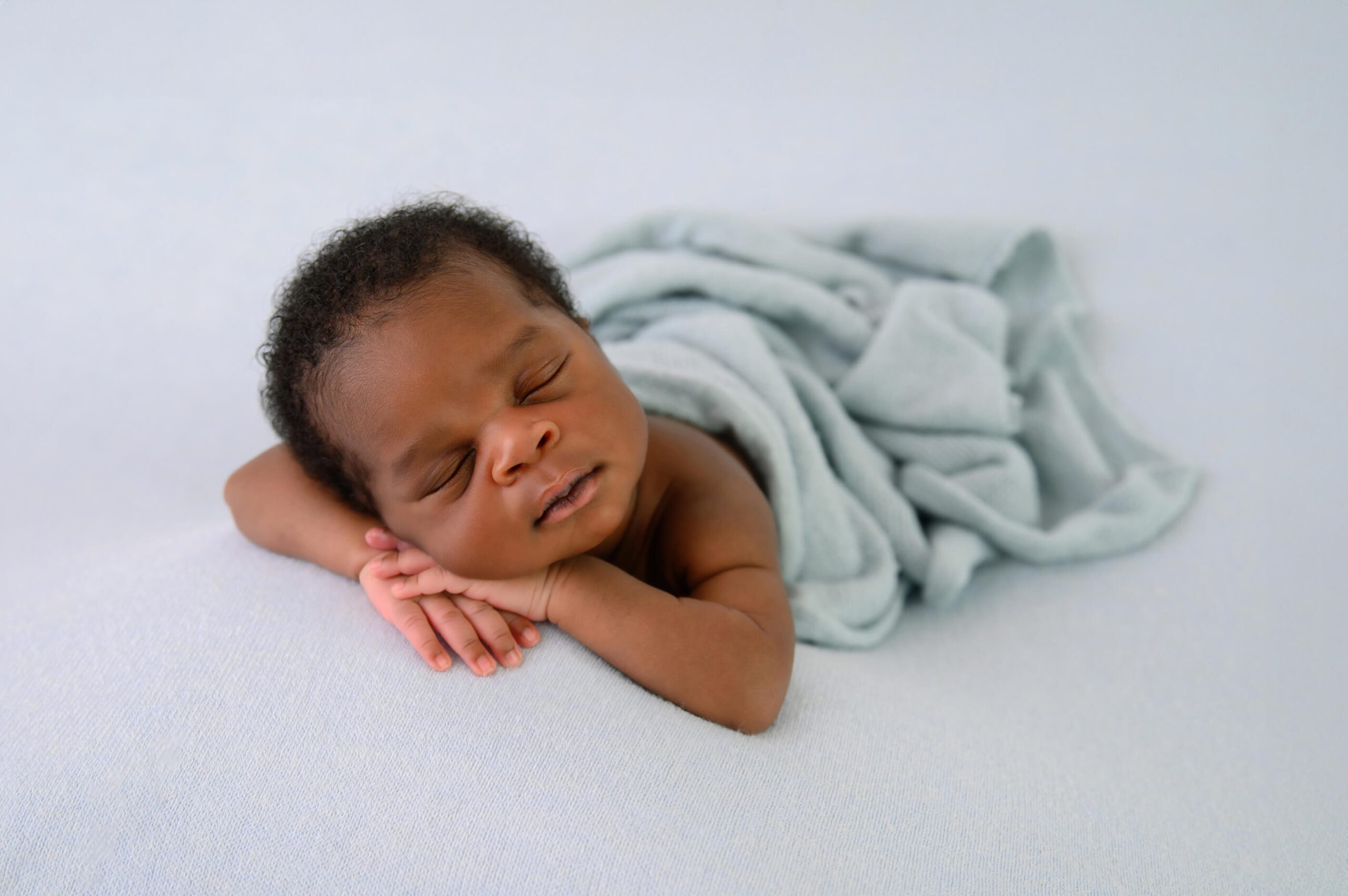 baby boy on a blue background for his Toronto Newborn Photography session.