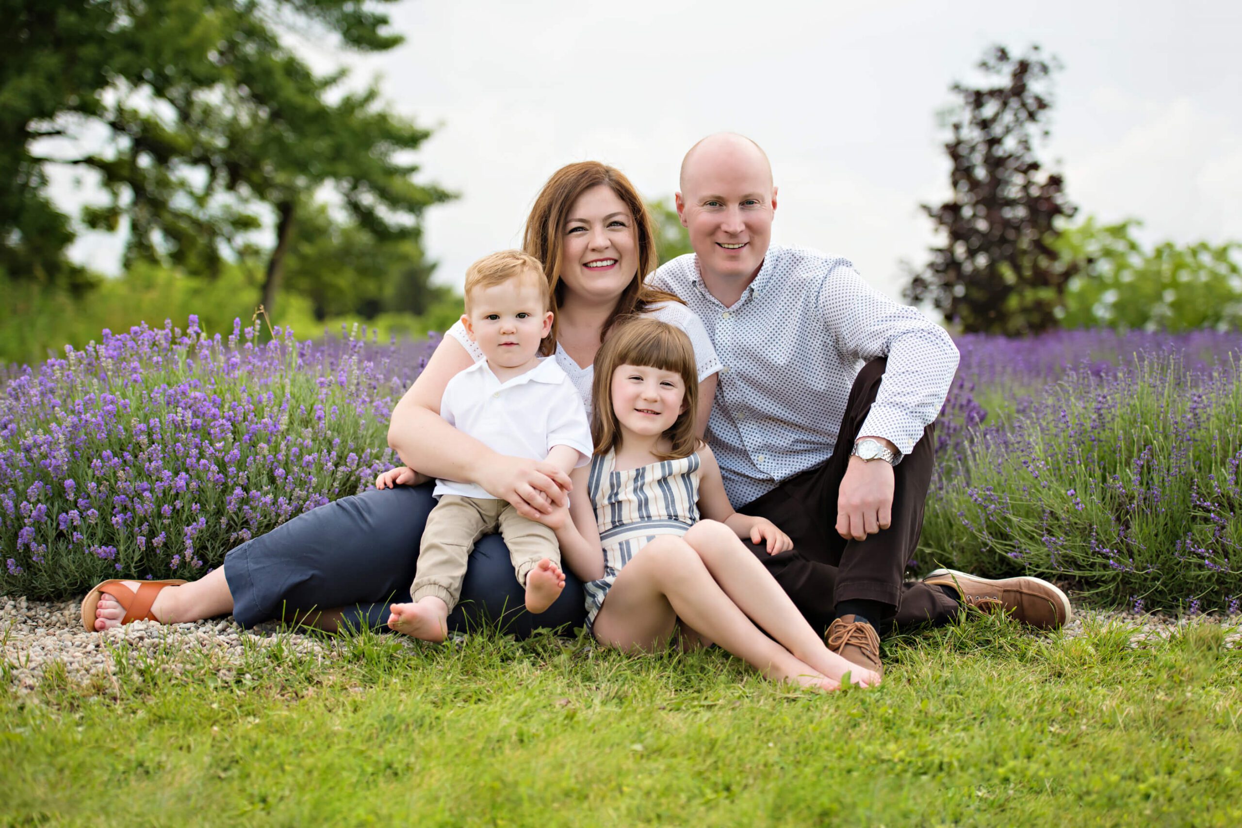 Mom and Dad sitting in the lavender with their son and daughter for their outdoor family photos.